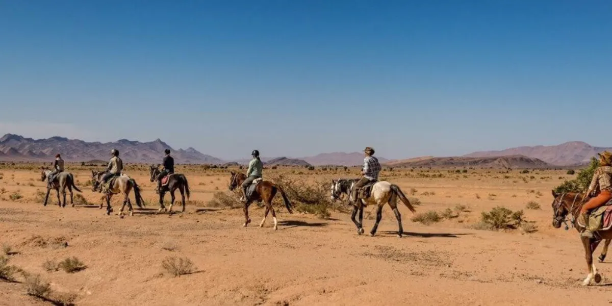 Riders on horseback crossing a desert trail in Morocco